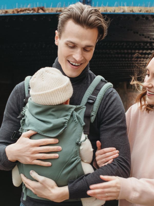 Padre portando alegremente a su beb&eacute; en la mochila E-Carrier Diamond Green de Quokkababy
